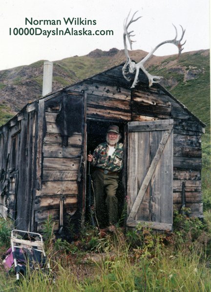 Bearded man in doorway of old cabin