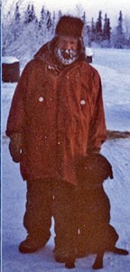 Man in red parka and icy beard with a dog